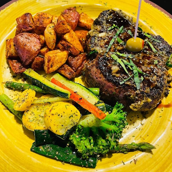 Viney's Italian Kitchen steak with roasted potatoes, zucchini, yellow squash, broccoli, and asparagus.